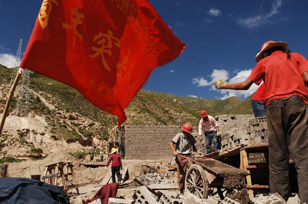 Workers work at a construction site at Changu Village of quake-hit Yushu in northwest China's Qinghai Province, July 6, 2010. The reconstruction work is underway in Changu Village and a total of 206 permanent houses will be finished on August 20, according to the reconstruction plan.