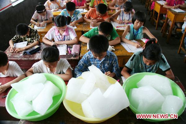 Ice cubes are placed in a classroom to ease the heat, where pupils are taking their terminal examination, at the Central Primary School of Tancheng Town in Tancheng County, east China&apos;s Shandong Province, July 7, 2010. [Xinhua]