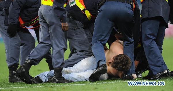 Security men subdue a man after he ran onto the field following the 2010 World Cup semi-final match between Germany and Spain in Durban, South Africa, July 7, 2010. Spain won 1-0. [Xinhua] 