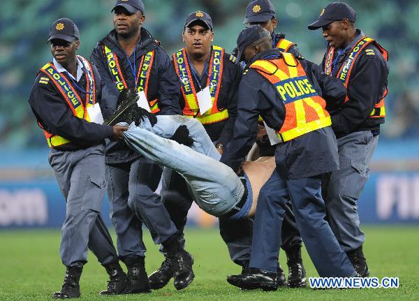 Security men force a man off the field after he ran onto the field after the 2010 World Cup semi-final match between Germany and Spain in Durban, South Africa, July 7, 2010. Spain won 1-0. [Xinhua] 