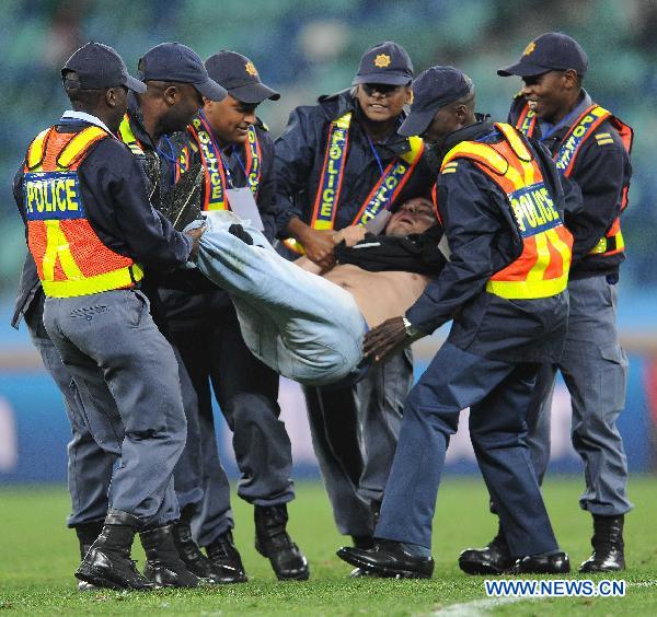 Security men force a man off the field after he ran onto the field following the 2010 World Cup semi-final match between Germany and Spain in Durban, South Africa, July 7, 2010. Spain won 1-0. [Xinhua] 