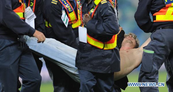 Security men subdue a man after he ran onto the field following the 2010 World Cup semi-final match between Germany and Spain in Durban, South Africa, July 7, 2010. Spain won 1-0. [Xinhua]