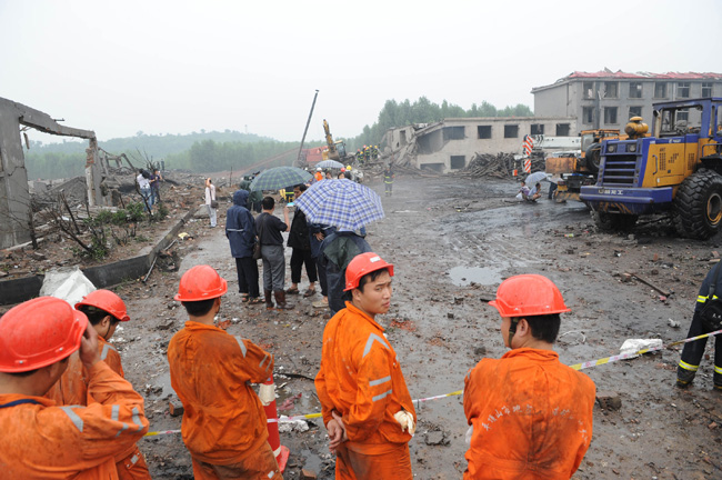 Rescuers wait to take orders to save people at Fenghuangling Coal Mine on July 8, 2010. [Xinhua]