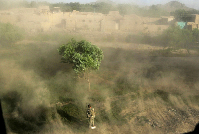 A soldier shields himself from rotor wash as a U.S. Army MEDEVAC helicopter from Charlie Co. Sixth Battalion, 101st Airborne Combat Aviation Brigade, Task Force Shadow takes off from a field after picking up wounded Afghan National Army soldiers June 22, 2010 near Kandahar, Afghanistan.[yeeyan.org]