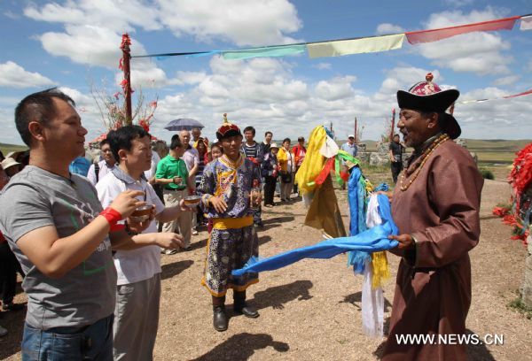 People participate a traditional welcoming ceremony in the Hulunbuir grassland of north China's Inner Mongolia Autonomous Region, July 6, 2010. The grassland entered the high tourist season recently.(Xinhua/Wang Yongji) 