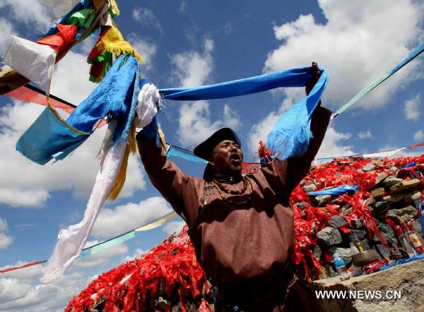 A local flamen acts at a traditional ceremony in the Hulunbuir grassland of north China's Inner Mongolia Autonomous Region, July 6, 2010. The grassland entered the high tourist season recently. [Xinhua/Wang Yongji] 