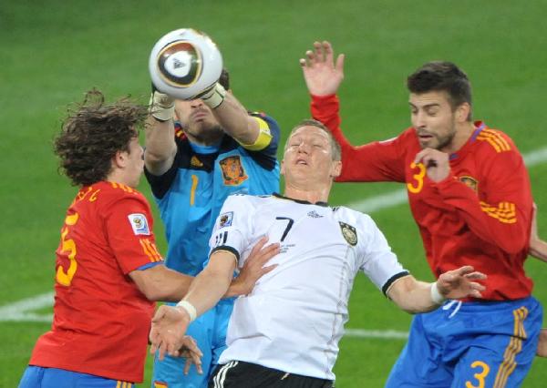 Spain's Iker Casillas (L2) makes a save beside Germany's Bastian Schweinsteiger (R2) during the 2010 World Cup semi-final match in Durban, South Africa, July 7, 2010. 