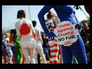 Protestors painted in the colours of flags of various countries hold signs and chant slogans during a demonstration against the fur industry in Johannesburg July 8, 2010. [163.com]