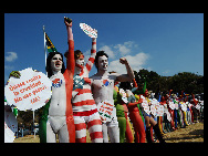 Protestors painted in the colours of flags of various countries hold signs and chant slogans during a demonstration against the fur industry in Johannesburg July 8, 2010. [163.com]