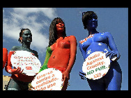 Protestors painted in the colours of flags of various countries hold signs and chant slogans during a demonstration against the fur industry in Johannesburg July 8, 2010. [163.com]