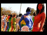 Protestors painted in the colours of flags of various countries hold signs and chant slogans during a demonstration against the fur industry in Johannesburg July 8, 2010. [163.com]