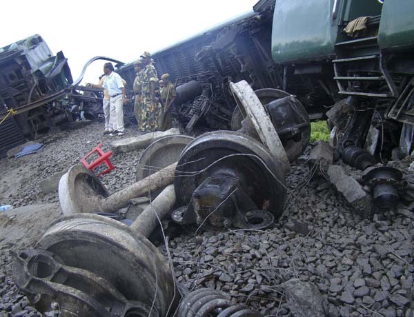 Railway officials examine derailed carriages of a passenger train after an explosion in Kokrajhar, in the northeastern Indian state of Assam, July 8, 2010.[Xinhua]