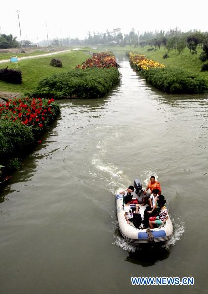 Excursionists revel in boating along the flowery brooklet on the upper reaches of Baihe River, with over 800,000 square meters of flowers and plants growing on the water surface that have remarkably beautified the ecological ambience and made it an tourist attraction in Shuangliu County, southwest China's Sichuan Province, July 7, 2010. (Xinhua) 