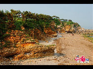 Known as a “Natural Geologic Museum,” the Golden Pebble Beach attracts tourists with splendid coves and rock formations on Dalian’s outskirts. [Photo by Zheng Yaofang]