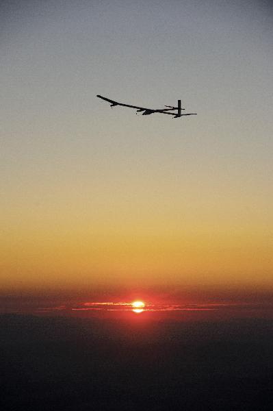 Solar Impulse&apos;s Chief Executive Officer and pilot Andre Borschberg flies the solar-powered HB-SIA prototype airplane at sunrise during the plane&apos;s first night flight attempt near Payerne airport July 8, 2010. [Xinhua/Reuters]