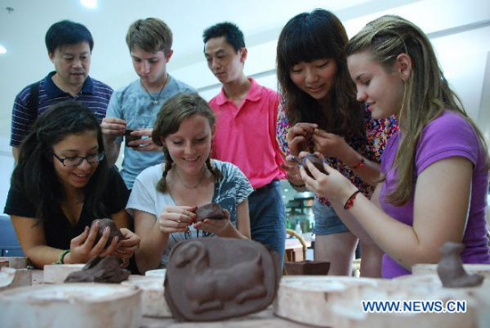 A group of high school students from Arizona of the United States learn the ceramics-making skill at the Ceramics Town of Yixing City, east China's Jiangsu Province, July 8, 2010. Yixing city, enjoying the fame as 'ceramics capital', has been one of China's major ceramics producers for 2,000 years. 