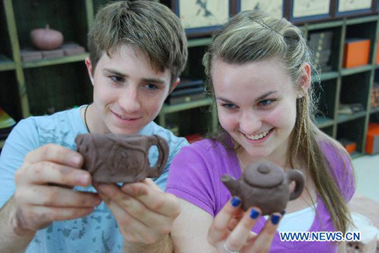 Two high school students from Arizona of the United States are joyous in showing up their own hand-made boccaro teapots at the Ceramics Town of Yixing City, east China's Jiangsu Province, July 8, 2010. Yixing city, enjoying the fame as 'ceramics capital', has been one of China's major ceramics producers for 2,000 years.