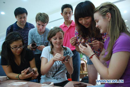 A group of high school students from Arizona of the United States join with Chinese students in learning to make boccaro teapot at the Ceramics Town of Yixing City, east China's Jiangsu Province, July 8, 2010. Yixing city, enjoying the fame as 'ceramics capital', has been one of China's major ceramics producers for 2,000 years.