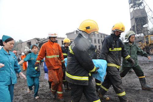 Rescue workers take a victim out of a collapsed building at Fenghuangling Coal Mine on July 8, 2010. [Photo/Xinhua] 