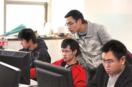 Huang Xuemin, standing, is one of the three founders of the 703804.com website . 