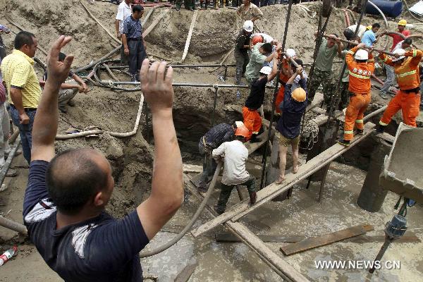 Rescuers work at a construction site in Nantong, east China's Jiangsu Province, July 8, 2010. A seven-year-old boy fell into a 15-meter-deep and 30-centimeter-in-diameter pile hole at the site around 6:00 p.m. local time Wednesday, and was successfully extricated after 20 hours' effort.