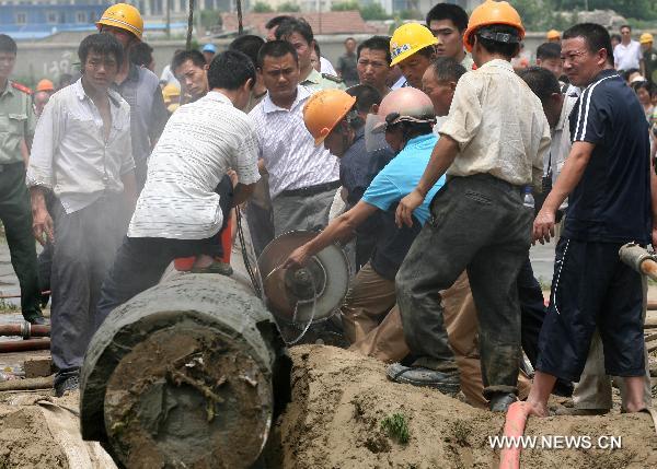 Rescuers cut a cement pile at a construction site in Nantong, east China's Jiangsu Province, July 8, 2010. A seven-year-old boy fell into a 15-meter-deep and 30-centimeter-in-diameter pile hole at the site around 6:00 p.m. local time Wednesday, and was successfully extricated after 20 hours' effort. 