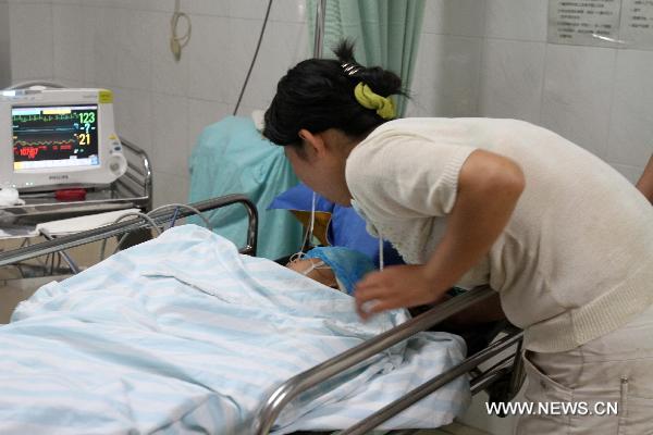 The rescued boy is comforted by his mother at a local hospital in Nantong, east China's Jiangsu Province, July 8, 2010. The seven-year-old boy fell into a 15-meter-deep and 30-centimeter-in-diameter pile hole at the site around 6:00 p.m. local time Wednesday, and was successfully extricated after 20 hours' effort. 