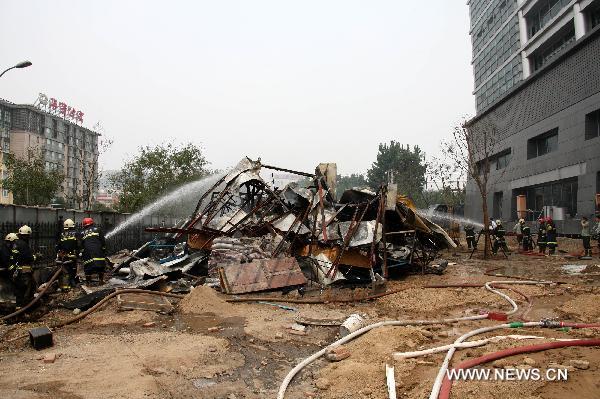 Firefighters try to put out a fire occurred in the northeast corner of north Naoshikou street of Chang'an Avenue of Beijing, capital of China, July 9, 2010.