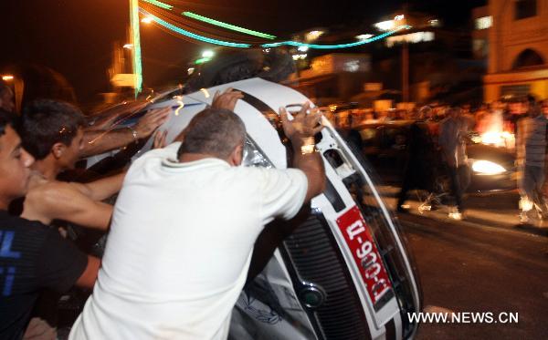 Local residents overturn a vehicle in the village of Majdal Shams, July 11, 2010. Syrian citizens in the Israeli-occupied Golan Heights captured three Israeli soldiers during a security mission by an Israeli force in the territory. The Israeli soldiers were in a mission to storm houses of two Syrian families in Majdal Shams village when the local citizens seized them inside one of the two houses. [Xinhua] 