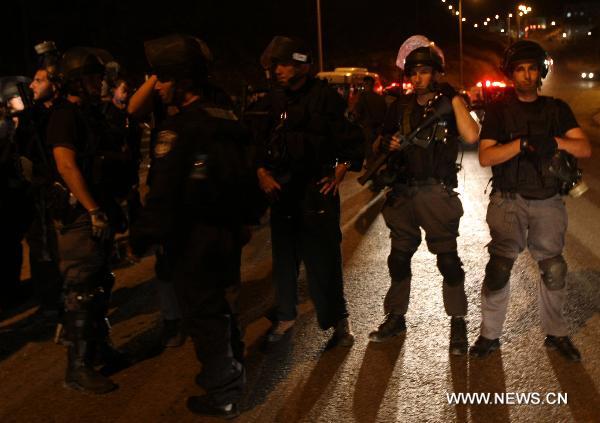 Israeli police officers stand guard during clashes between residents and Israeli police, in the village of Majdal Shams, July 11, 2010. Syrian citizens in the Israeli-occupied Golan Heights captured three Israeli soldiers during a security mission by an Israeli force in the territory. The Israeli soldiers were in a mission to storm houses of two Syrian families in Majdal Shams village when the local citizens seized them inside one of the two houses. [Xinhua] 