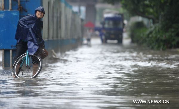 A citizen rides a bike on a rainy day in Hefei, capital of east China&apos;s Anhui Province, July 12, 2010. The provincial meteorological station raised the storm alert to &apos;orange&apos; Monday morning. China&apos;s Central Meteorological Station warned Sunday that rainstorms would again batter many provinces and regions in the coming days bringing with it bigger risks of new flooding and other geological disasters in central and eastern China.[Xinhua]