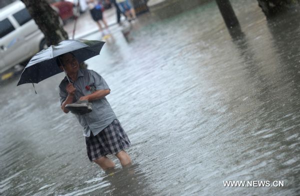 A citizen walks on a rainy day in Hefei, capital of east China&apos;s Anhui Province, July 12, 2010. The provincial meteorological station raised the storm alert to &apos;orange&apos; Monday morning. China&apos;s Central Meteorological Station warned Sunday that rainstorms would again batter many provinces and regions in the coming days bringing with it bigger risks of new flooding and other geological disasters in central and eastern China. [Xinhua]