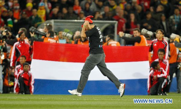 A fan enters the field to fetch the trophy before the final between the Netherlands and Spain at Soccer City stadium in Johannesburg, South Africa, July 11, 2010. [Xinhua]