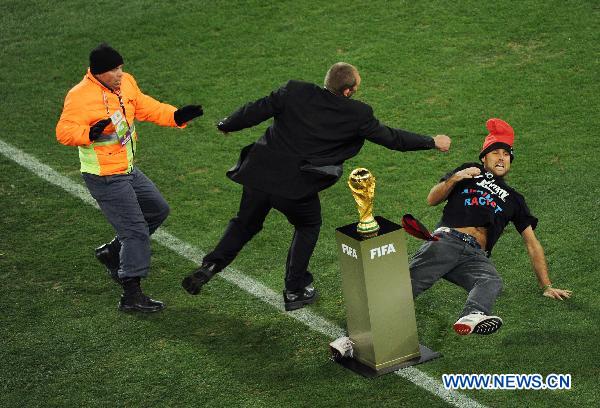 A security man knocks down a fan (R) attempting to fetch the trophy before the World Cup final between the Netherlands and Spain at Soccer City stadium in Johannesburg, South Africa, July 11, 2010. [Xinhua] 