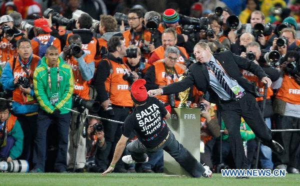 A security man (R) knocks down a fan attempting to fetch the trophy before the World Cup final between the Netherlands and Spain at Soccer City stadium in Johannesburg, South Africa, July 11, 2010. [Xinhua]