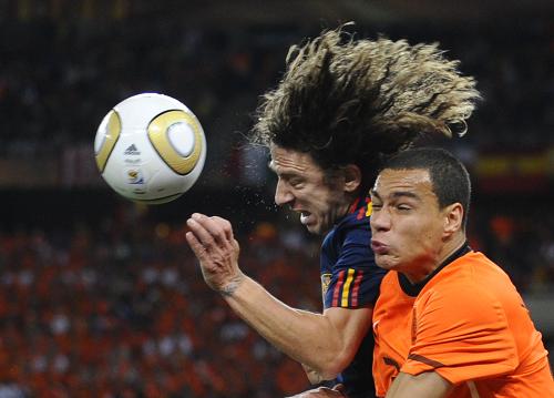 Spain's Carles Puyol (left), and Netherlands' Gregory van der Wiel challenge for the ball during the World Cup final soccer match between the Netherlands and Spain at Soccer City in Johannesburg, South Africa, Sunday, July 11, 2010.