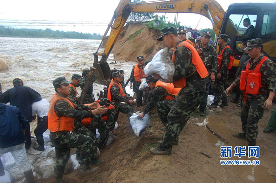 Police officers and soldiers fill the breaches with sandbags on the Dasha River, Anhui Province, on July 11. 