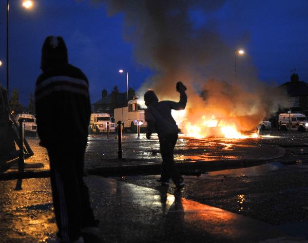 A Nationalist throws a missile at police in the Ardoyne area, north Belfast July 12, 2010. Nationalists in Northern Ireland attacked police with petrol bombs and other missiles during parades by the pro-British Orange Order on Monday, witnesses said.[Xinhua]