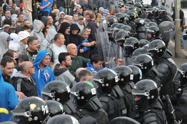 Police dressed in riot gear remove Nationalists blocking the Crumlin Road in the Ardoyne area, north Belfast July 12, 2010.[Xinhua]