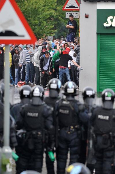 Police and nationalist protesters clash before an Orange Order march in north Belfast, Northern Ireland, Monday July 12, 2010.[Xinhua]