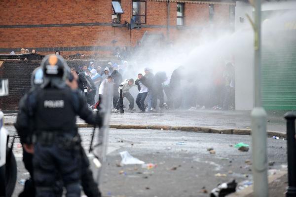 Police and nationalist protesters clash before an Orange Order march in north Belfast, Northern Ireland, Monday July 12, 2010.[Xinhua]