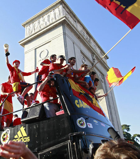 Spain's national soccer team players look out from an open-top bus past Arco de la Victoria during a celebration parade in downtown Madrid, July 12, 2010. Spain stunned the Netherlands to win their first World Cup on Sunday in sensational fashion with a goal in the last minutes of extra time. (Xinhua/Reuters Photo)