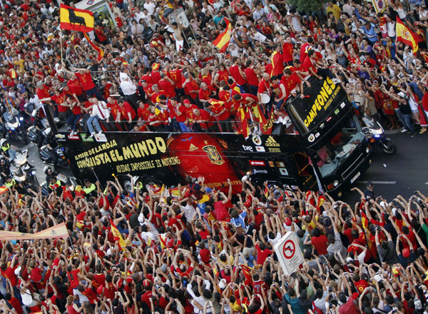 Crowds gather around Spain's national soccer team players as they celebrate their World Cup victory on an open-top bus during a parade in downtown Madrid, July 12, 2010. Spain stunned the Netherlands to win their first World Cup on Sunday in sensational fashion with a goal in the last minutes of extra time. (Xinhua/Reuters Photo)