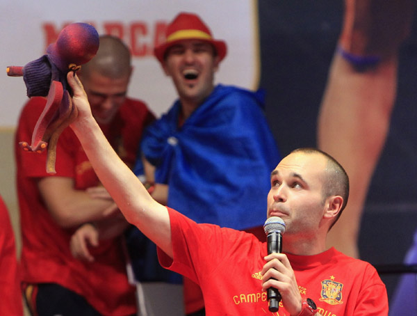 Spain's Andres Iniesta holds a mock version of Paul the oracle octopus as he and his team mates celebrate their World Cup victory on a stage in Madrid July 12, 2010. The octopus, who lives in an aquarium in the German city of Oberhausen, had picked Spain to beat the Netherlands in Sunday's final. (Xinhua/Reuters Photo)