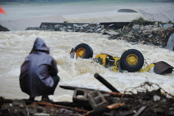 An excavator is seen flushed in the flood at the breached dyke along the Qingcao section of the Dasha River, in Tongcheng City, east China's Anhui Province, July 12, 2010. [Photo/Xinhua]