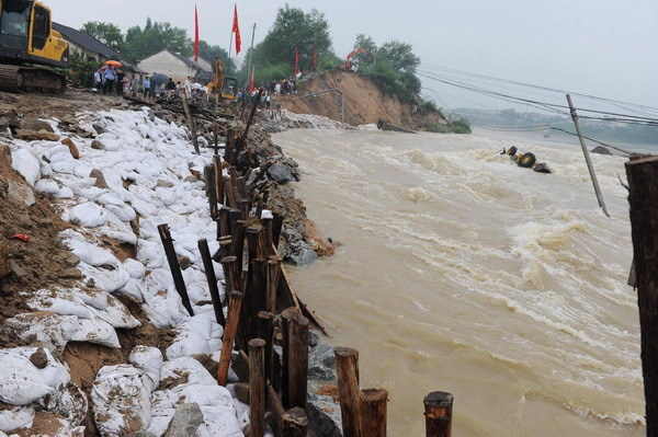 The dyke consolidation project under way along the Qingcao section of the Dasha River, in Tongcheng City, east China's Anhui Province, July 12, 2010. [Photo/Xinhua]