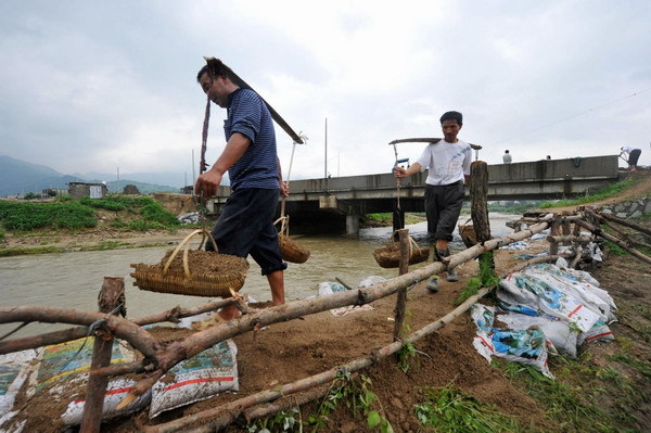 Villagers proceed with rescue work in Yuexi county, Anhui province on July 12, 2010. [Photo/Xinhua]