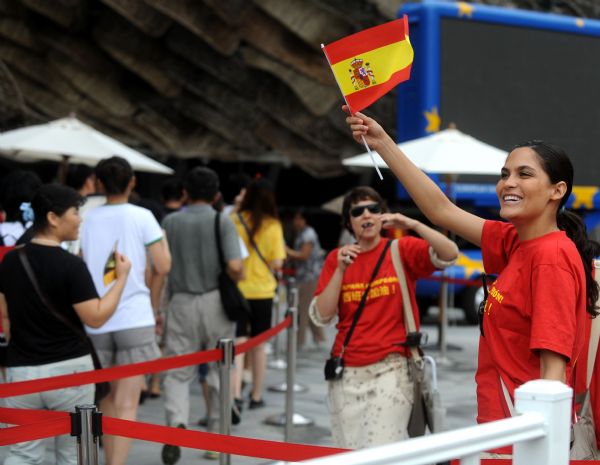 A staff member waves a national flag of Spain outside the Spain Pavilion at the 2010 World Expo in Shanghai, east China, July 12, 2010. Spain won the football world cup for the first time in their history after defeating Holland in the final. 