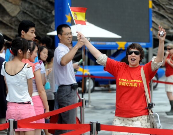 A staff member waves a national flag of Spain outside the Spain Pavilion at the 2010 World Expo in Shanghai, east China, July 12, 2010. Spain won the football world cup for the first time in their history after defeating Holland in the final. 