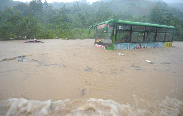 A bus and a car are stalled in the flood waters in Chizhou city of East China&apos;s Anhui province, July 13, 2010. [Xinhua]